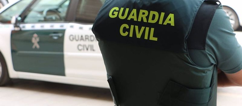 Agent de la Guardia Civil espagnole présentant des fonds saisis lors d'une arnaque amoureuse
